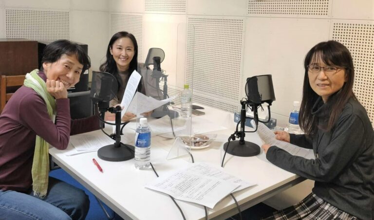 Tre kvinner rundt et bord med mikrofoner i et radiostudio